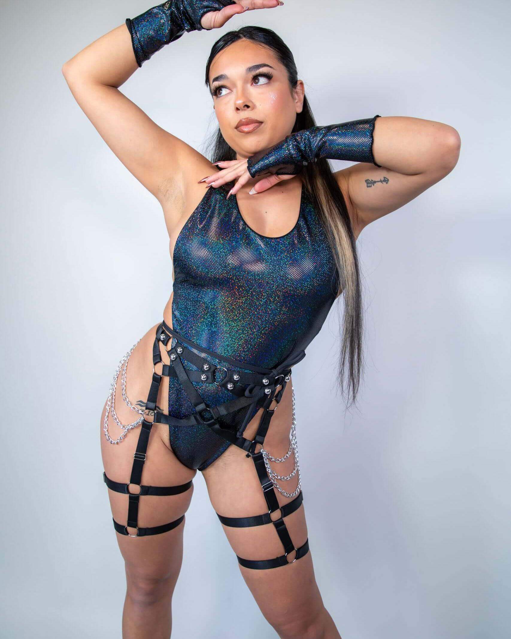 Model showcasing a bold rave outfit with glittering bodysuit and stylish harness, perfect for festival fashion.