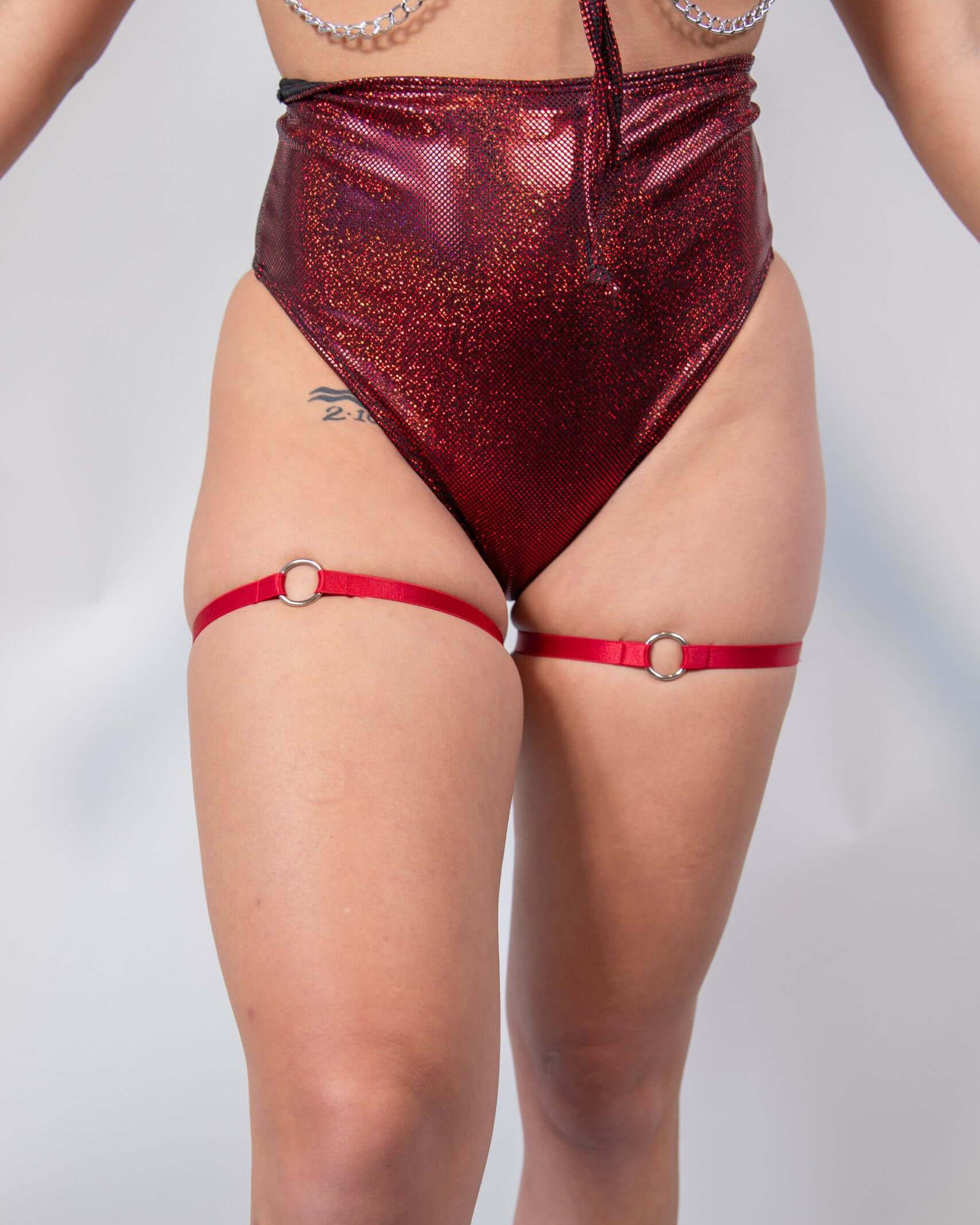 O-Ring leg garter set in red worn with high-waisted sparkly shorts, perfect for bold rave outfits.