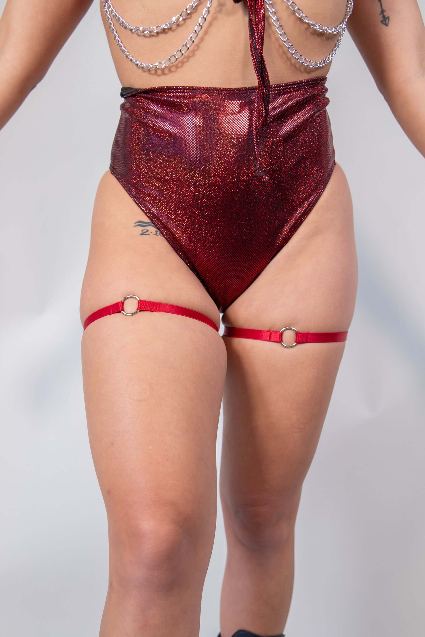 O-Ring leg garter set in red worn with high-waisted sparkly shorts, perfect for bold rave outfits.