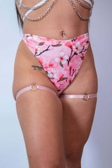 Light pink leg garters with o-ring detail paired with floral high-waisted bottoms, perfect for rave outfits.