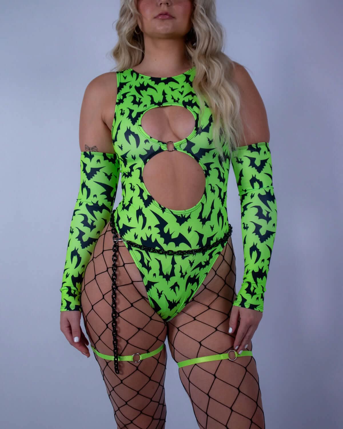 Model wearing OG Batty Keyhole Bodysuit - UV Green, featuring vibrant bat print and striking cutouts, perfect for rave outfits.