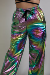 Holographic swirl rave pants, front view, vibrant reflective pattern, high-waisted design, stylish and comfortable for rave wear.