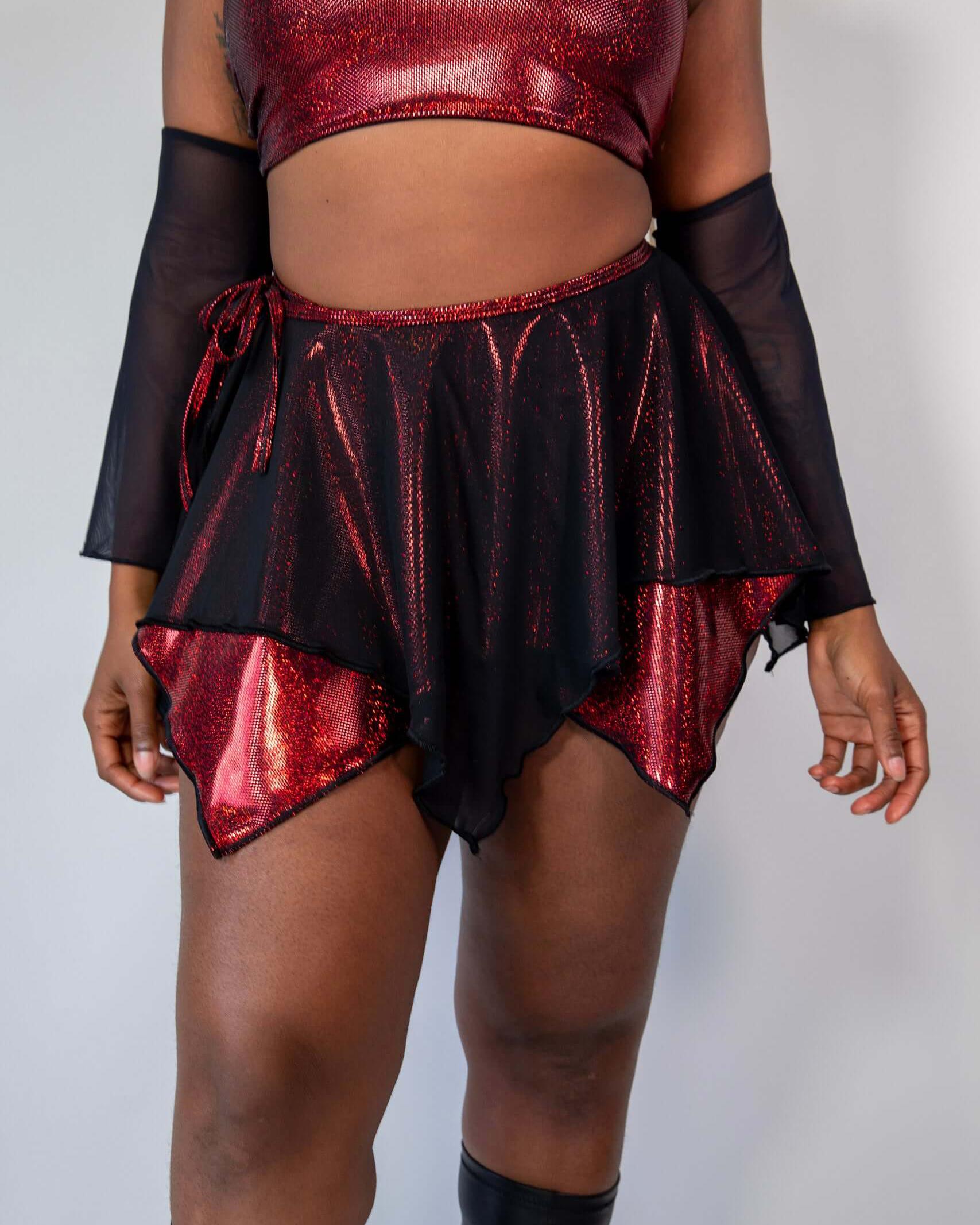 Model wearing the Phoenix Fairy Skirt, a sparkly red double-layered hankerchief skirt, perfect for rave outfits.