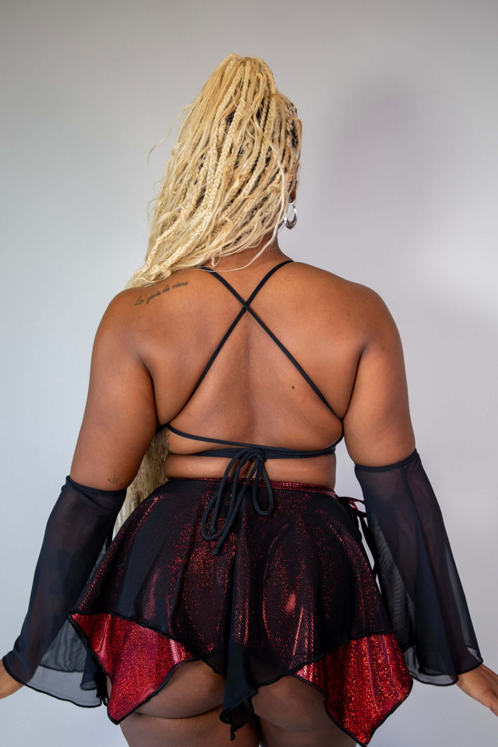 Rear view of the Phoenix Lush Top showcasing black mesh accents, crisscross straps, and a striking red design, perfect for making a statement at festivals.