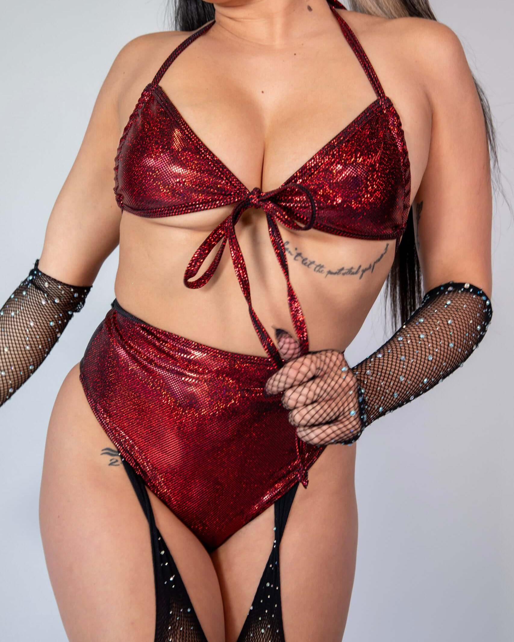 Model wearing the red sparkly Phoenix Wrap Bikini Top, styled for raves with fishnet gloves and high-cut bikini bottoms.