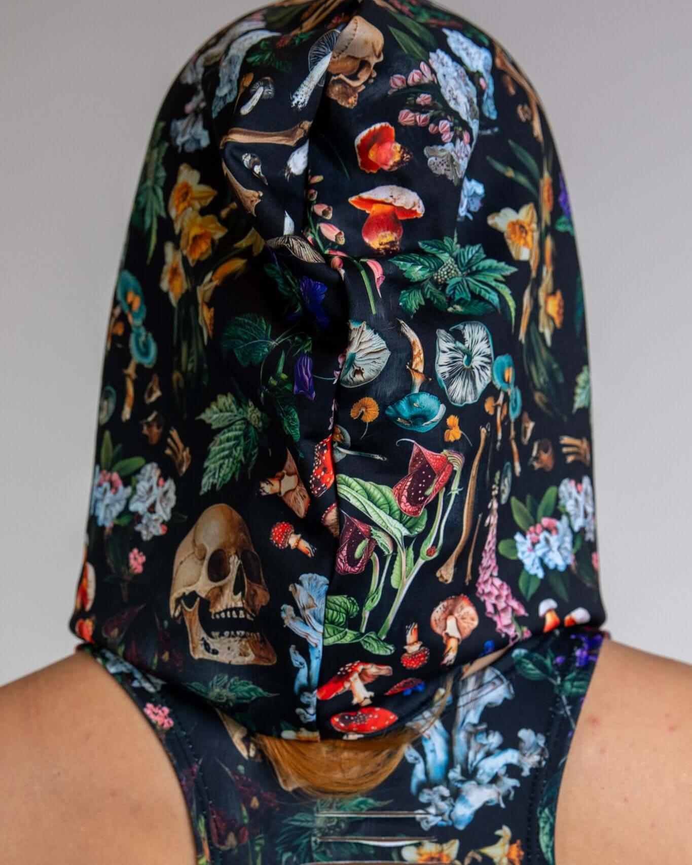 Poison Assassin Hood featuring a bold skull and mushroom print, perfect for edgy rave outfits and streetwear.