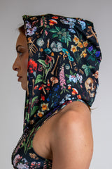 Model wearing Poison Assassin Hood for festival fashion with a bold, vibrant abstract design on black background, side view.. 