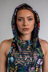 Model wearing Poison Assassin Hood with vibrant skulls and floral print, perfect for rave outfits and edgy streetwear.