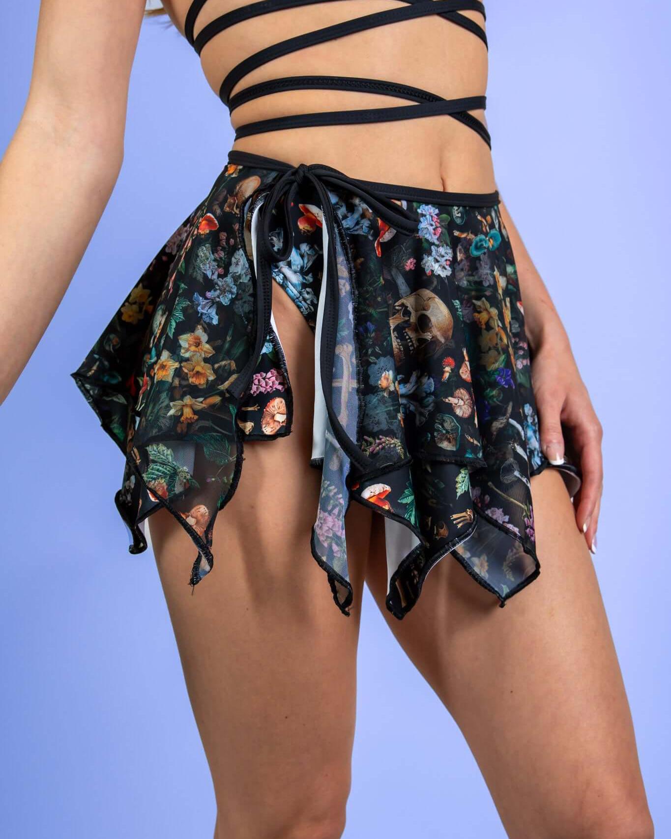 Poison Fairy Skirt featuring a bold print of skulls and mushrooms, perfect for rave outfits with a flowy asymmetrical design.