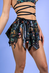 Poison Fairy Skirt featuring a bold print of skulls and mushrooms, perfect for rave outfits with a flowy asymmetrical design.