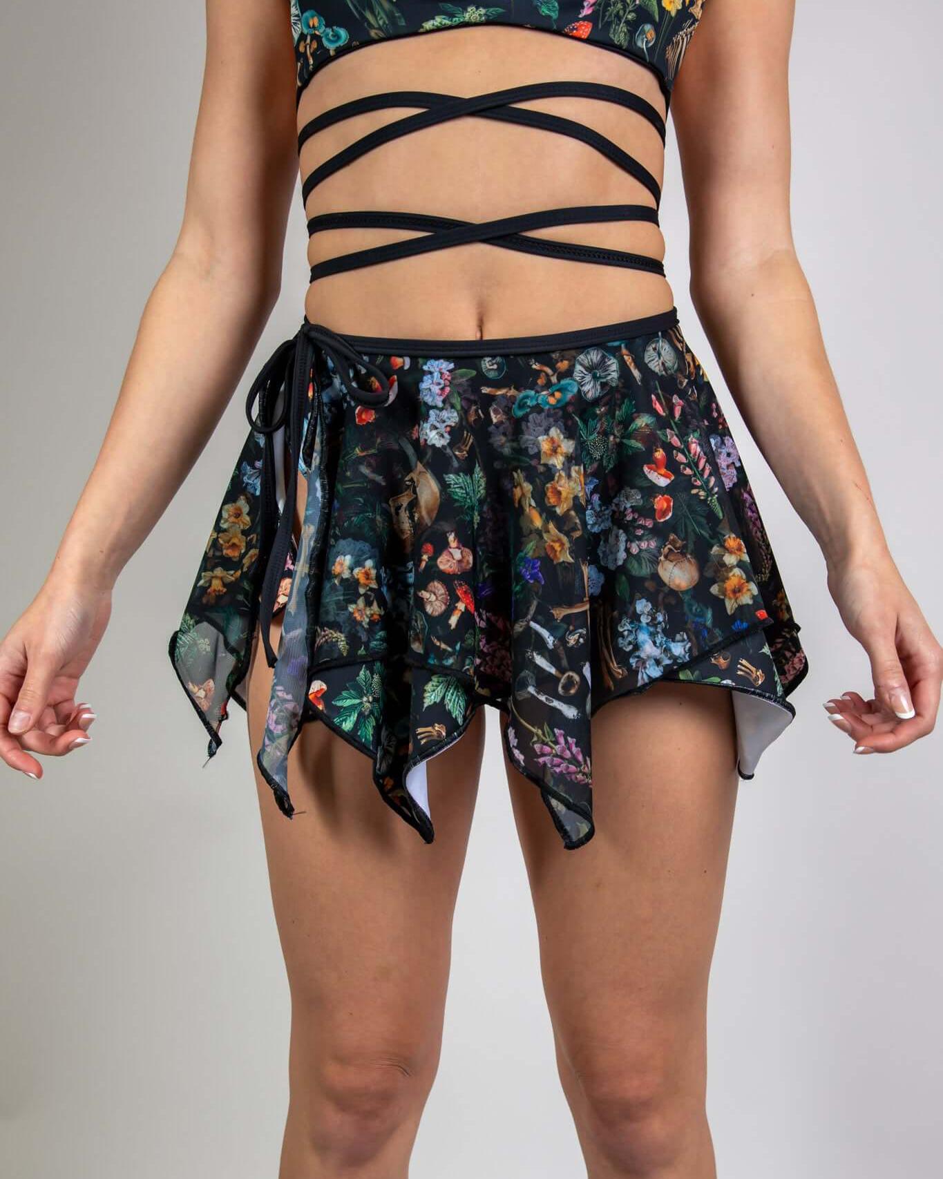 Model wearing the Poison Fairy Skirt, featuring a floral print, paired with a black strappy top, ideal for rave outfits.