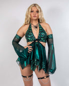Model showcasing the Predator Fairy Skirt, featuring a shimmering green design perfect for rave outfits.