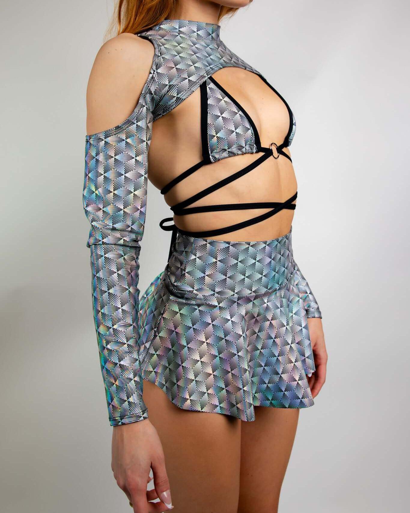 Woman wearing a Prism Spectra sleeve top and matching skirt, showcasing futuristic rave outfit design and shoulder cutout.