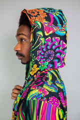 Close-up side profile of a man wearing a Freedom Rave Wear hood in psychedelic print with vibrant floral patterns.