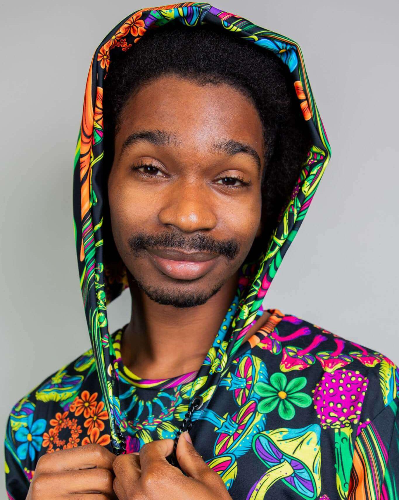 Young man wearing the colorful PsyBloom Assassin Hood, showcasing vibrant rave outfits and unique festival fashion.