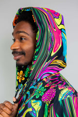 Side profile of a smiling man wearing a colorful hooded garment with psychedelic swirls and floral patterns, complemented by a black chain