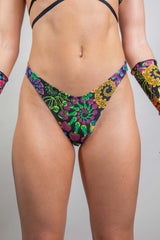 Close-up view of Freedom Rave Wear high-waisted rave bottoms featuring a psychedelic floral print in vibrant colors. The design includes intricate details and a snug fit that accentuates a dynamic rave-ready style.