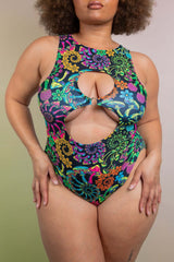 Model in a Freedom Rave Wear Psybloom bodysuit with keyhole cutouts, flaunting a psychedelic mushroom floral print for a captivating rave attire.
