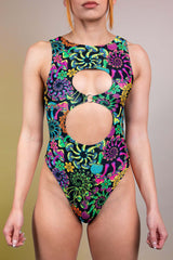 Front view of a Freedom Rave Wear Psybloom bodysuit with distinctive circular keyhole cutouts, adorned with a vivid neon floral print.