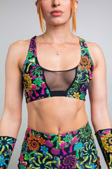 Close-up of a model wearing Freedom Rave Wear's floral V-neck top with mesh detail, paired with vibrant, high-waisted leggings, perfect for a colorful and trendy rave look.
