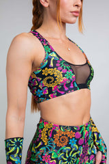 Side view of a model in Freedom Rave Wear's floral V-neck top featuring a mesh cutout, complemented by vibrant, high-waisted shorts, ideal for festival fashion.