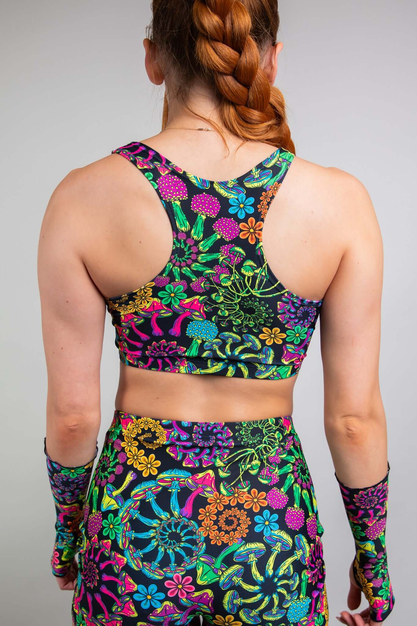 Rear view of a model sporting Freedom Rave Wear's colorful floral racerback top and shorts, highlighting a detailed and vivid print, perfect for standout rave attire.