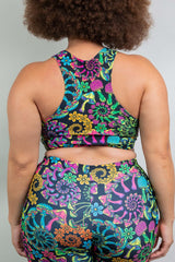 Rear view of a model in Freedom Rave Wear's floral racerback top and matching high-waisted shorts, displaying a vibrant and eye-catching pattern ideal for festival fashion.
