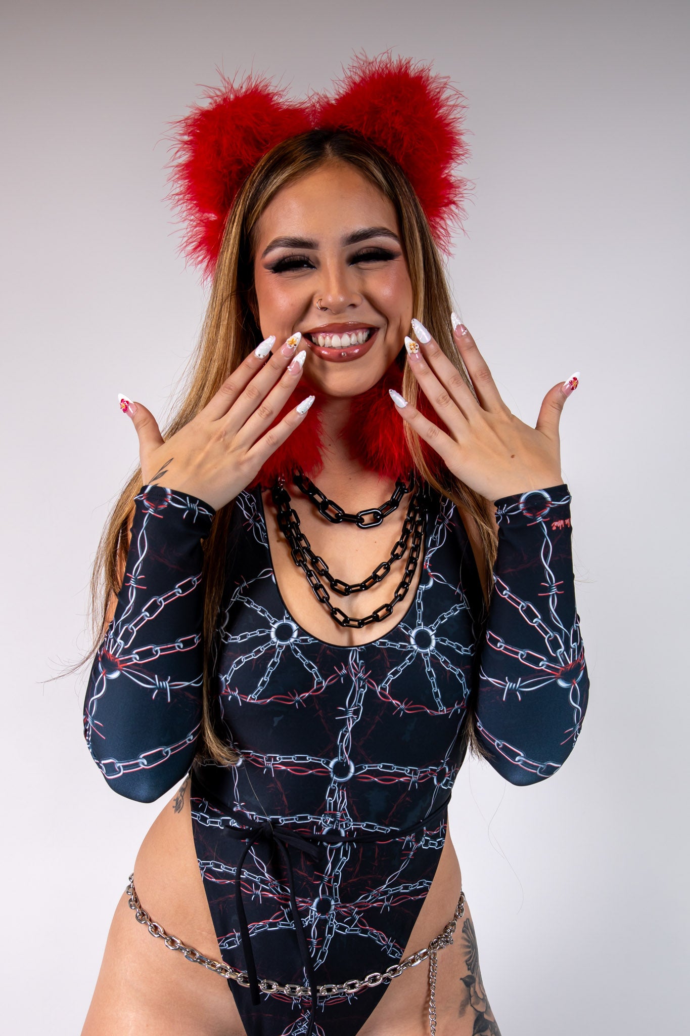 Model wearing Purgatory Arm Sleeves with chain and barbed wire pattern, paired with festival outfit for bold, edgy style.