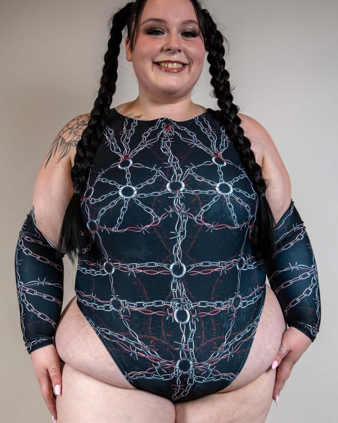 Plus-size model wearing a stylish chain-printed bodysuit with long sleeves, perfect for rave outfits.