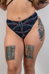 Model wearing Purgatory High Waisted Thong with bold chain graphic and tattoos, perfect for rave outfits.