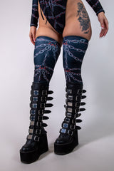 Purgatory Leg Sleeves with bold chain graphic, perfect for rave outfits and dancing, paired with stylish platform boots.