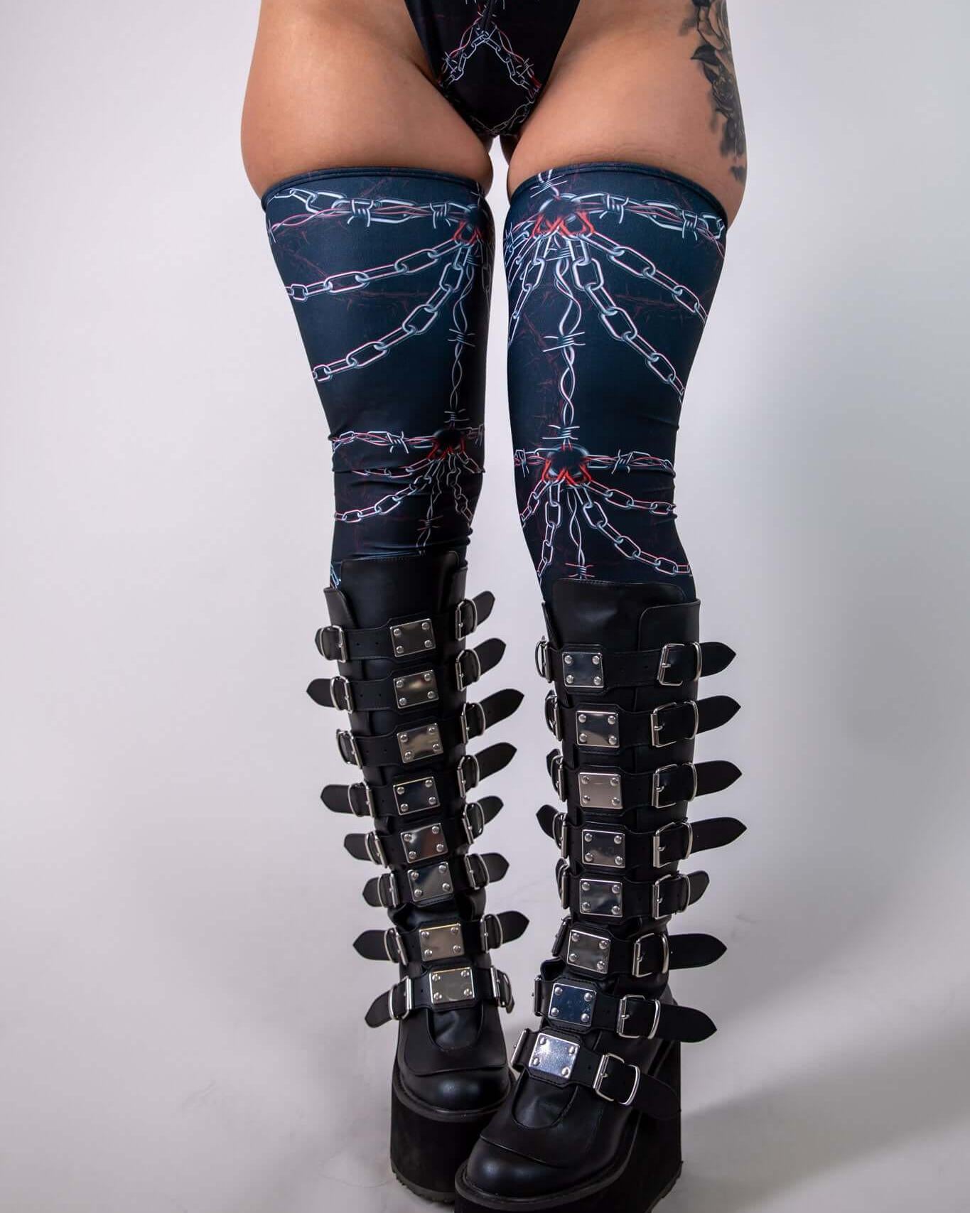 Sleek Purgatory Leg Sleeves with bold chain graphic, styled with edgy platform boots for rave outfits.