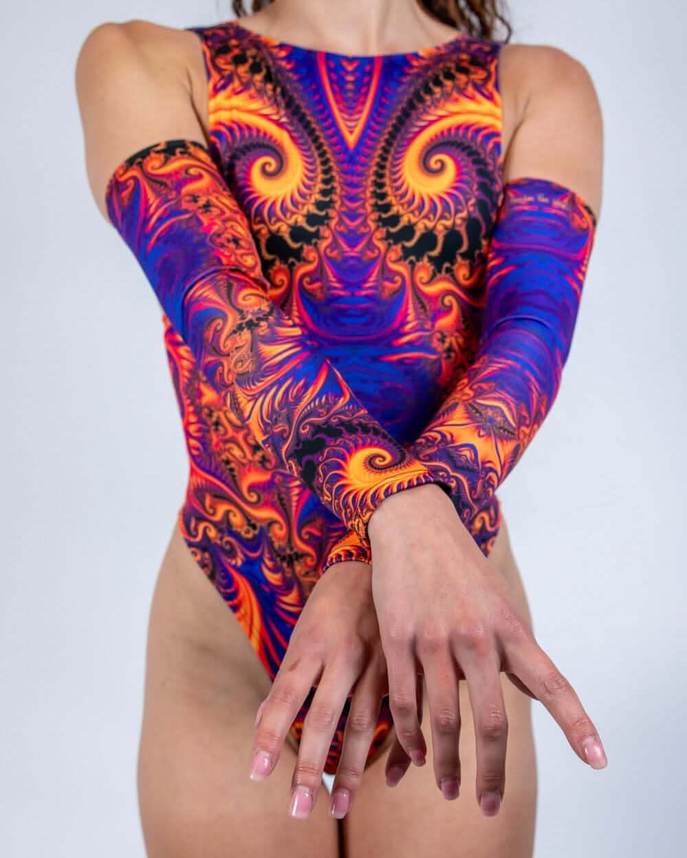 Model showcasing Radiance Arm Sleeves with vibrant fractal patterns in orange and purple, ideal for rave outfits.