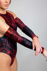 Side view of a model showcasing Freedom Rave Wear's red and black circuit pattern bodysuit paired with full-length arm sleeves, highlighting the intricate design and sleek fi