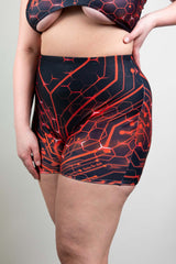 Freedom Rave Wear high-waisted shorts in red and black circuit design, modeled from the side on a plain background