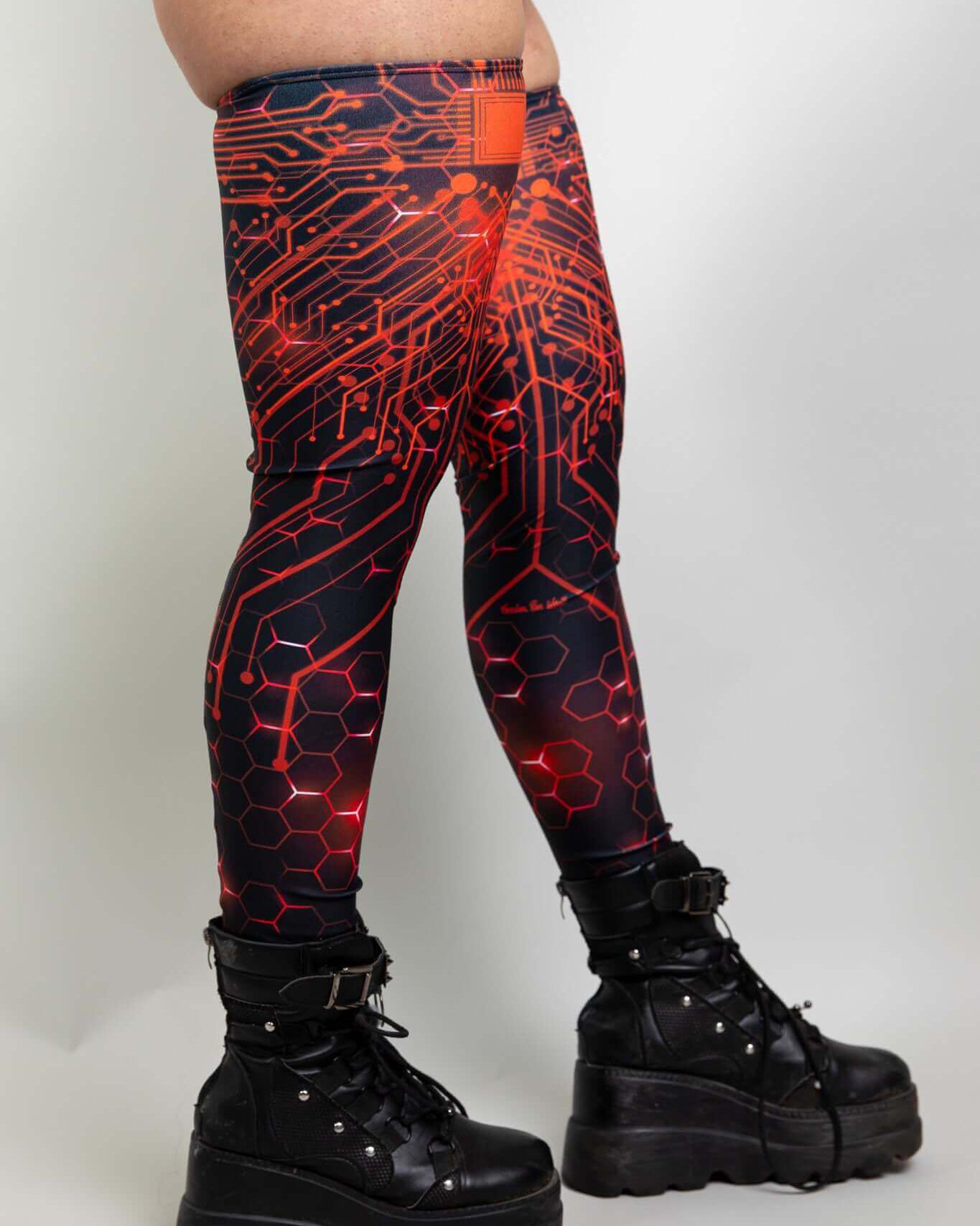 Side view of red and black leg sleeves with circuitry design, paired with chunky black boots, ideal for rave outfits.