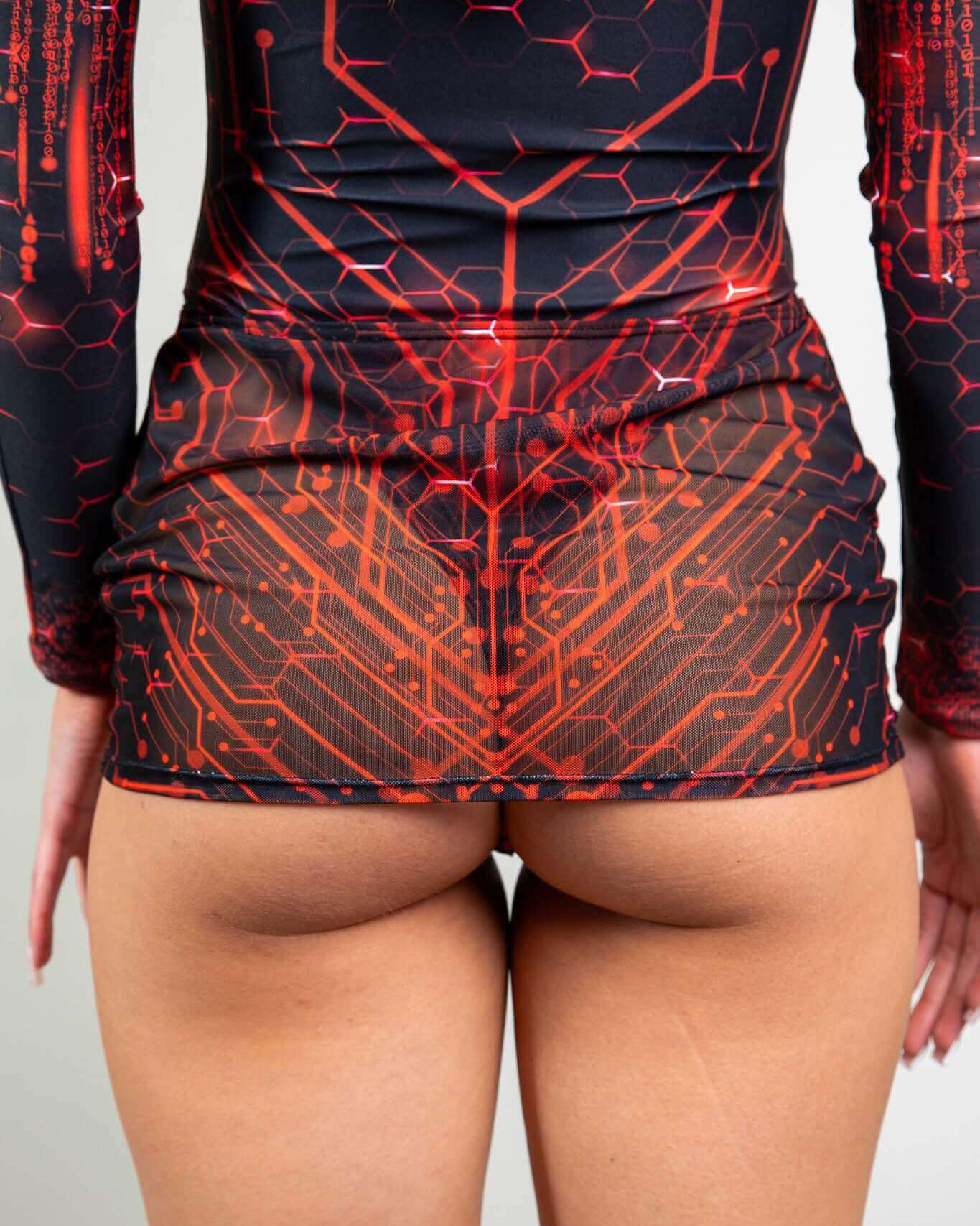 Model wearing a red circuit pattern mesh mini skirt, showcasing a stylish and bold rave outfit. Ideal for festival fashion.