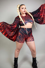 Model in dynamic pose with Freedom Rave Wear circuit-pattern outfit and pashmina, accented by dramatic braids and black boots