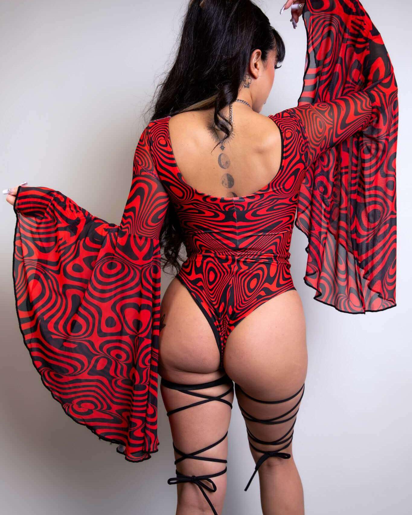 Woman showcasing the Red Void Goddess Bodysuit with dramatic sleeves and lace-up detailing, perfect for rave outfits.