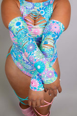 Model in Freedom Rave Wear bodysuit, showcasing vivid floral sleeves with playful cut-outs and pastel color details.