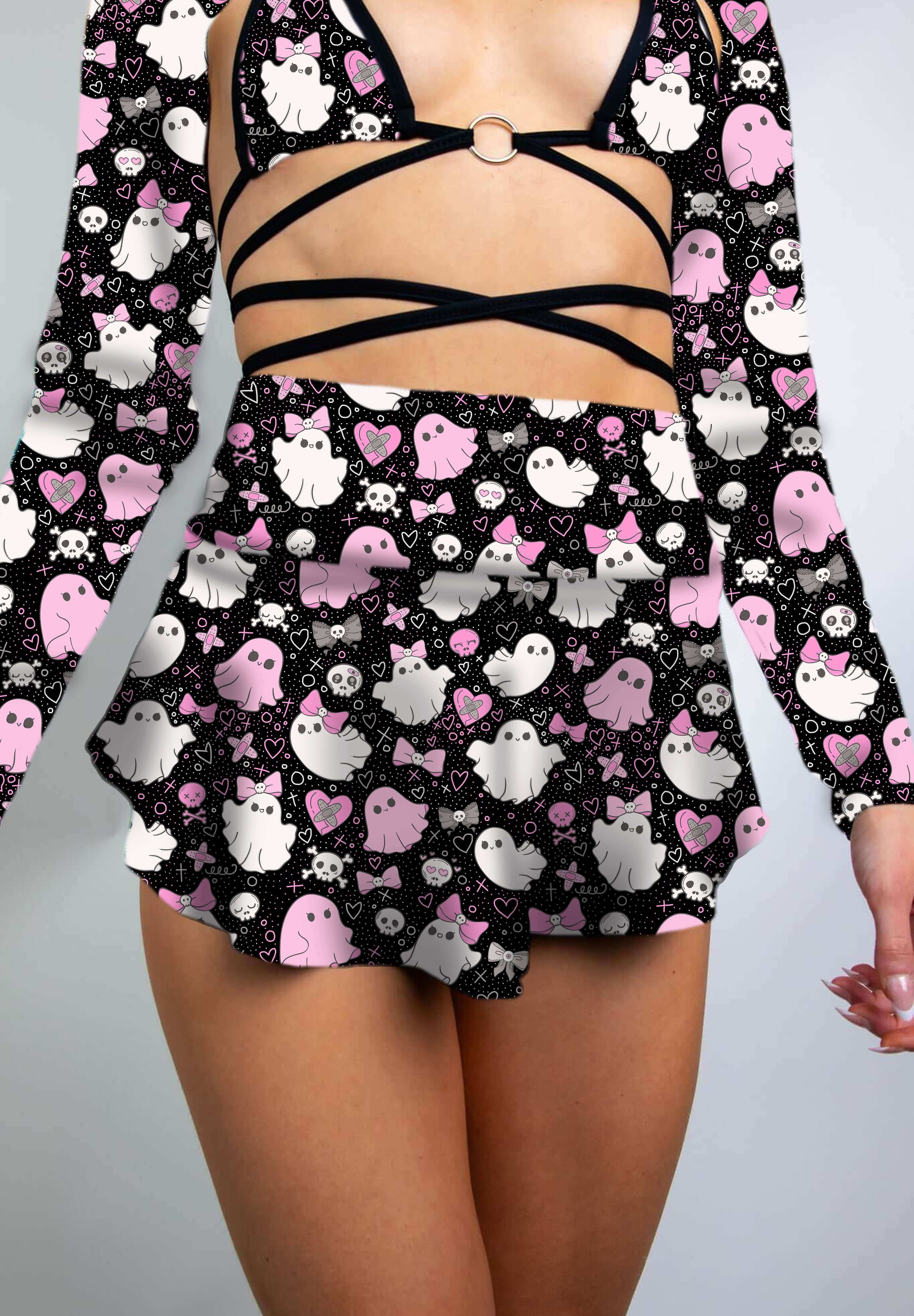 Close-up of a model in a black skater skirt with pink and white spooky ghost print, styled with a cutout crop top.