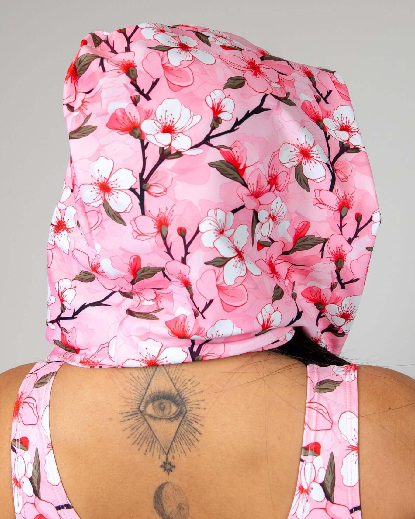 Sakura assassin hood with pink cherry blossom design worn, showcasing a stylish festival accessory for rave outfits.