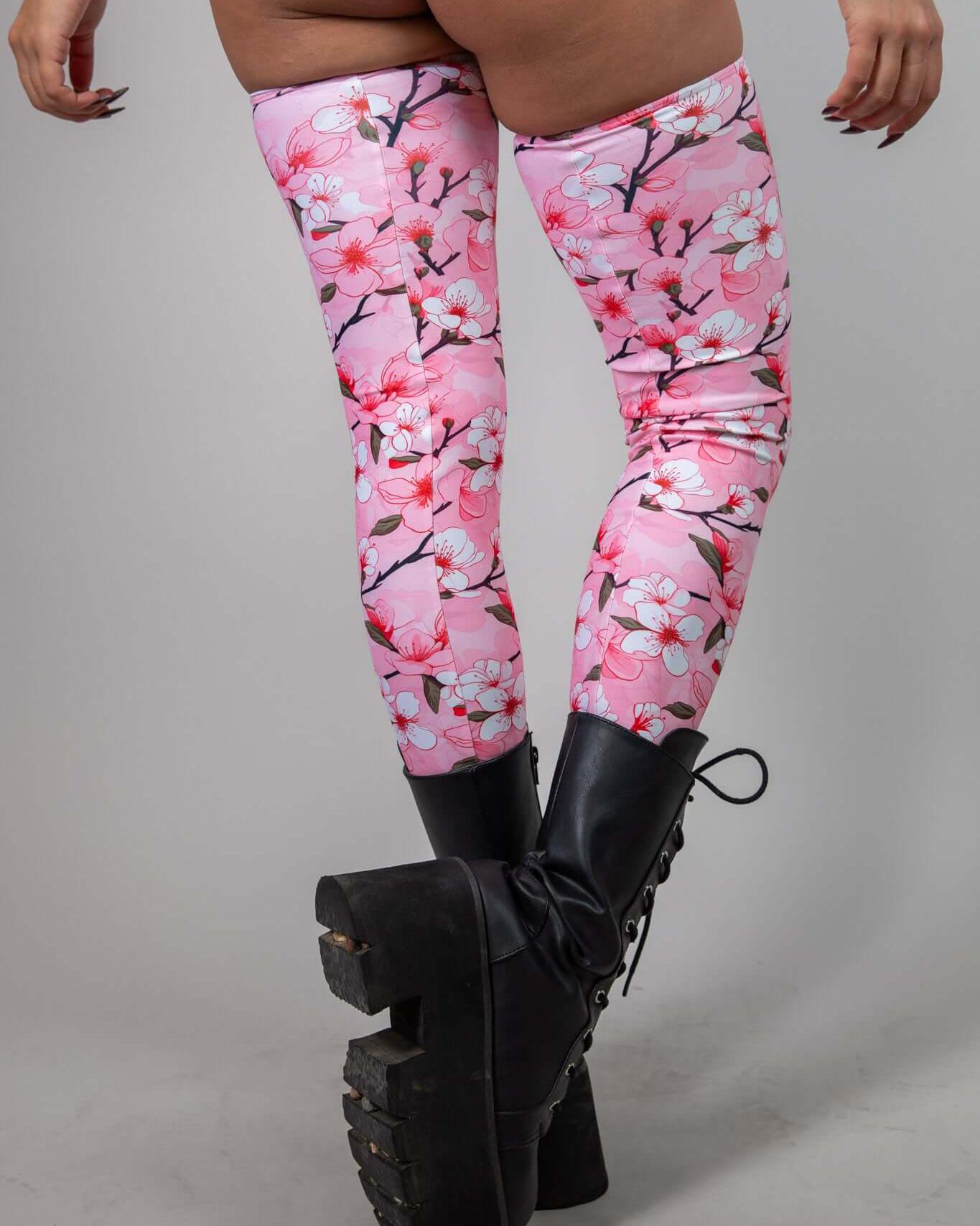 Sakura leg sleeves in pink cherry blossom design, paired with black platform boots, ideal for rave outfits and festivals.