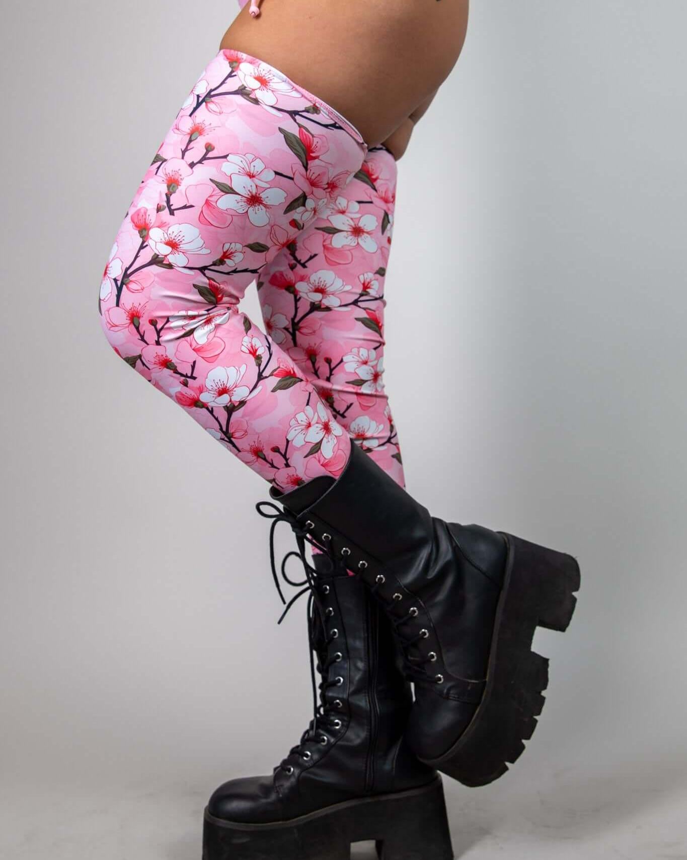 Sakura leg sleeves with pink cherry blossom design paired with black platform boots, perfect for rave outfits.