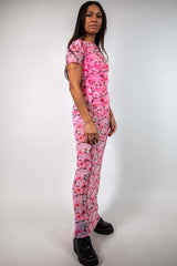 Side view of pink mesh maxi dress with baby tee design and white and pink cherry blossom print, styled with black boots, perfect for rave fashion.