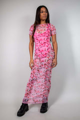 Full-body view of pink mesh maxi dress with baby tee design and white and pink cherry blossom print, styled with black boots, perfect for festivals.