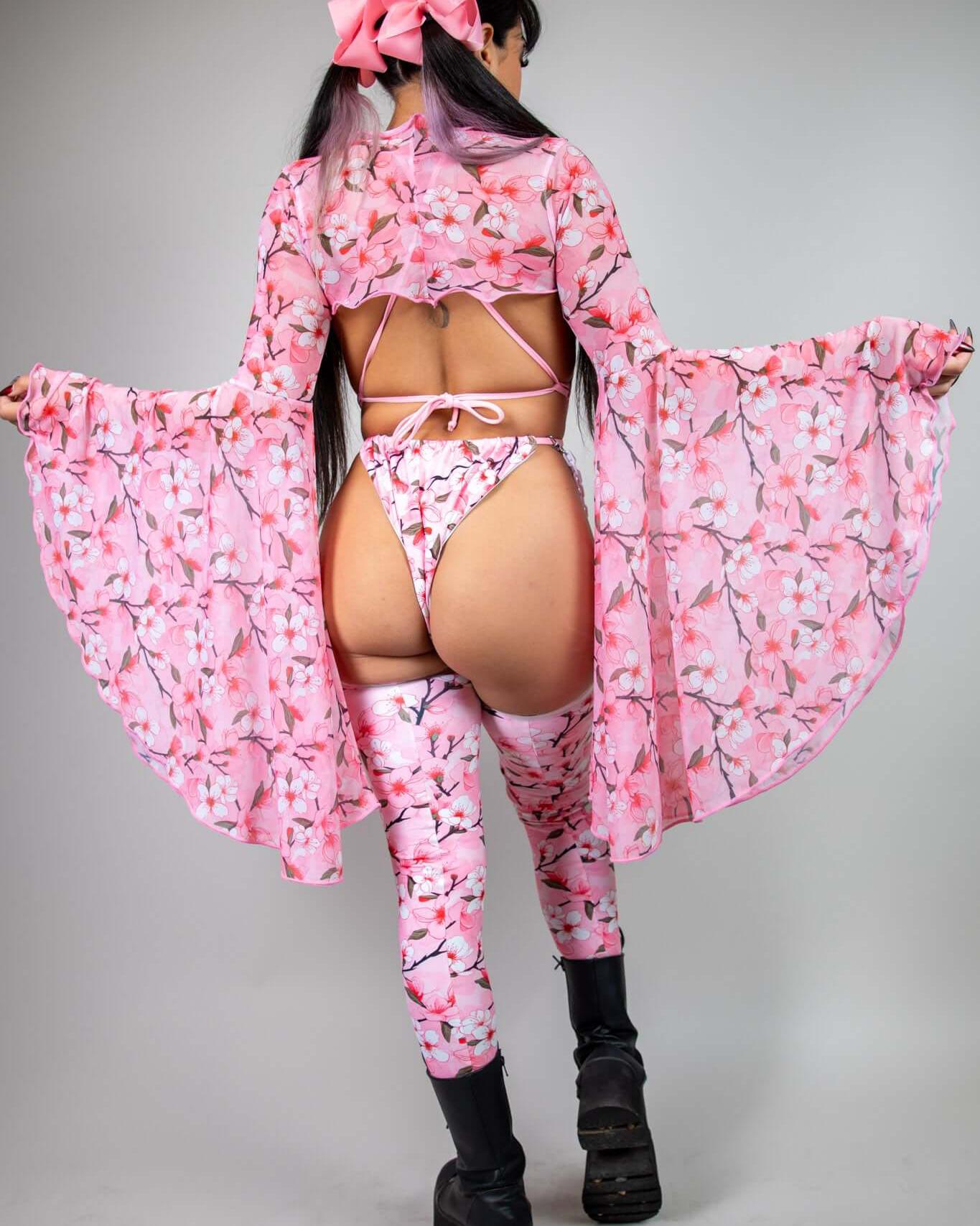 Model showcasing Sakura Mesh Bell Sleeves with pink cherry blossom design, perfect for rave outfits and stylish statements.