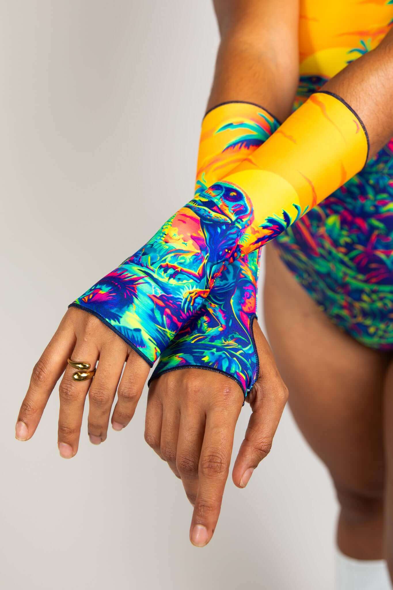 Detailed shot of colorful dinosaur print arm sleeves, perfectly matching the vibrant rave bodysuit from Freedom Rave Wear.