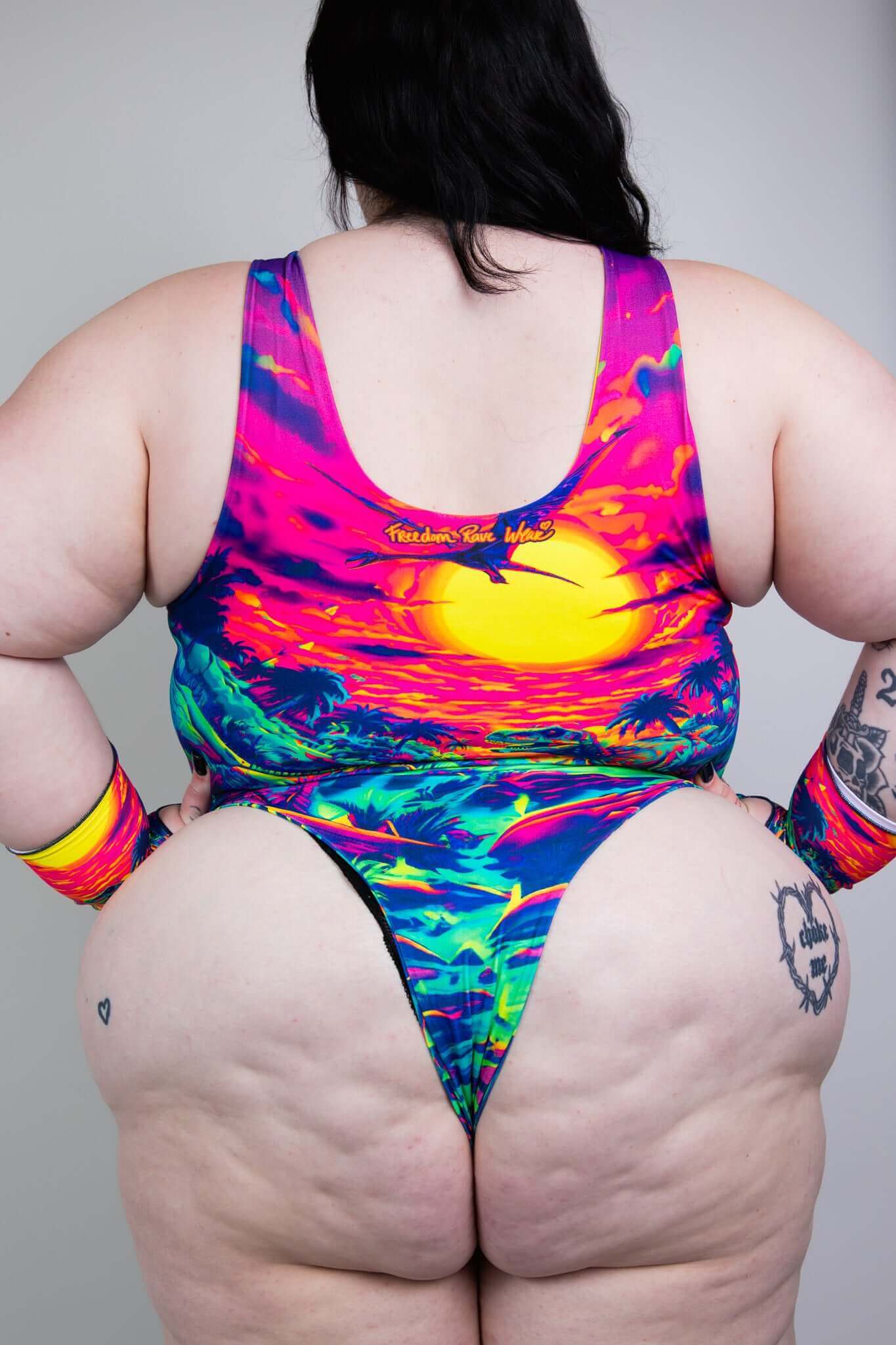 Freedom Rave Wear plus-size rave bodysuit featuring a neon dinosaur and sunset design. Perfect for vibrant, bold rave styles.