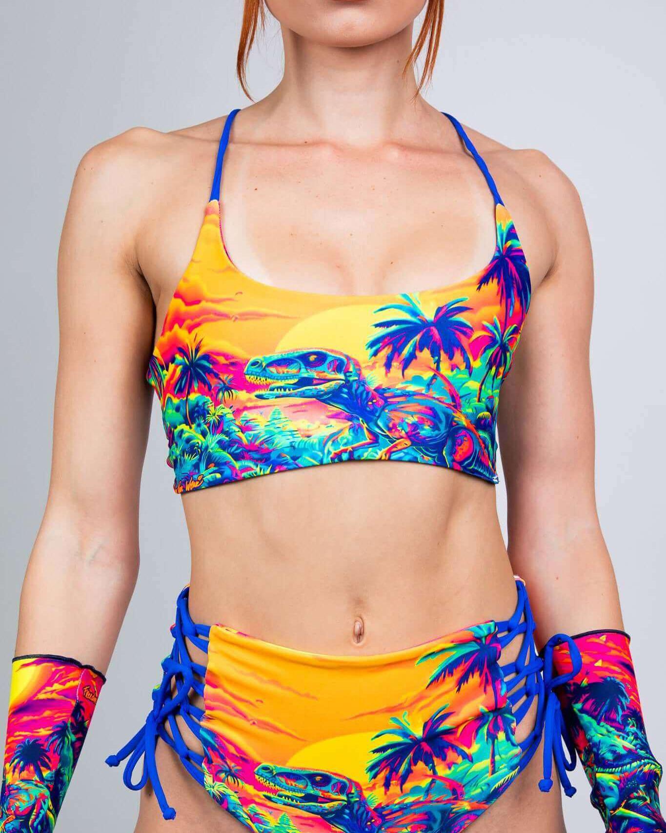 Model wearing a vibrant Saurian Reversible Lush Top, showcasing bold colors and dinosaur patterns, perfect for rave outfits.